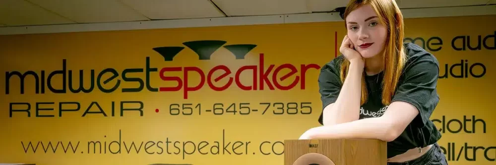 Girl w/ Red Hair with Speakers in front of Midwest Speaker Banner